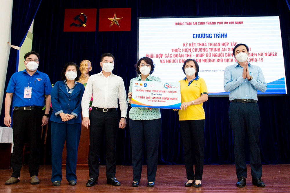 Ông Nguyễn Đình Trung - Chủ tịch Tập đoàn Hưng Thịnh (thứ ba từ trái qua) cùng đại diện ban tổ chức chương trình "Vòng tay Việt - Sài Gòn" chung tay trao tặng một triệu suất ăn cho người nghèo tại TP.HCM